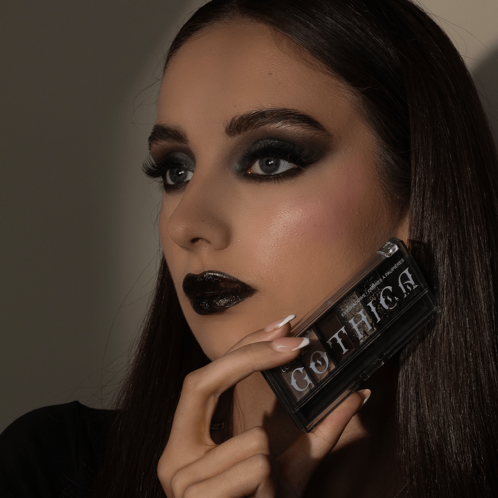 Model holding the darkside gothica eyeshadow palette next to face.
