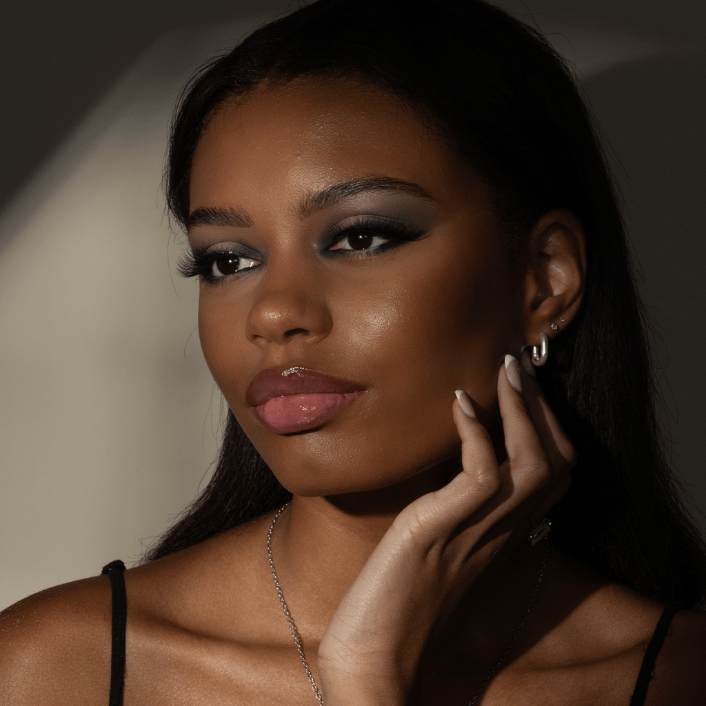 Model with lip gloss applied with full face of makeup.