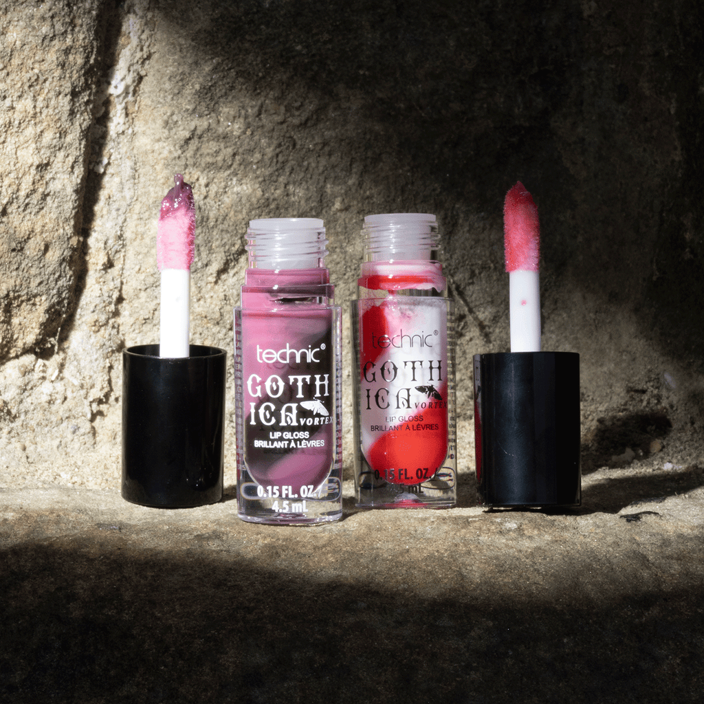 Both swirl lip glosses opened next to each other, on a stone wall with shadow effect.