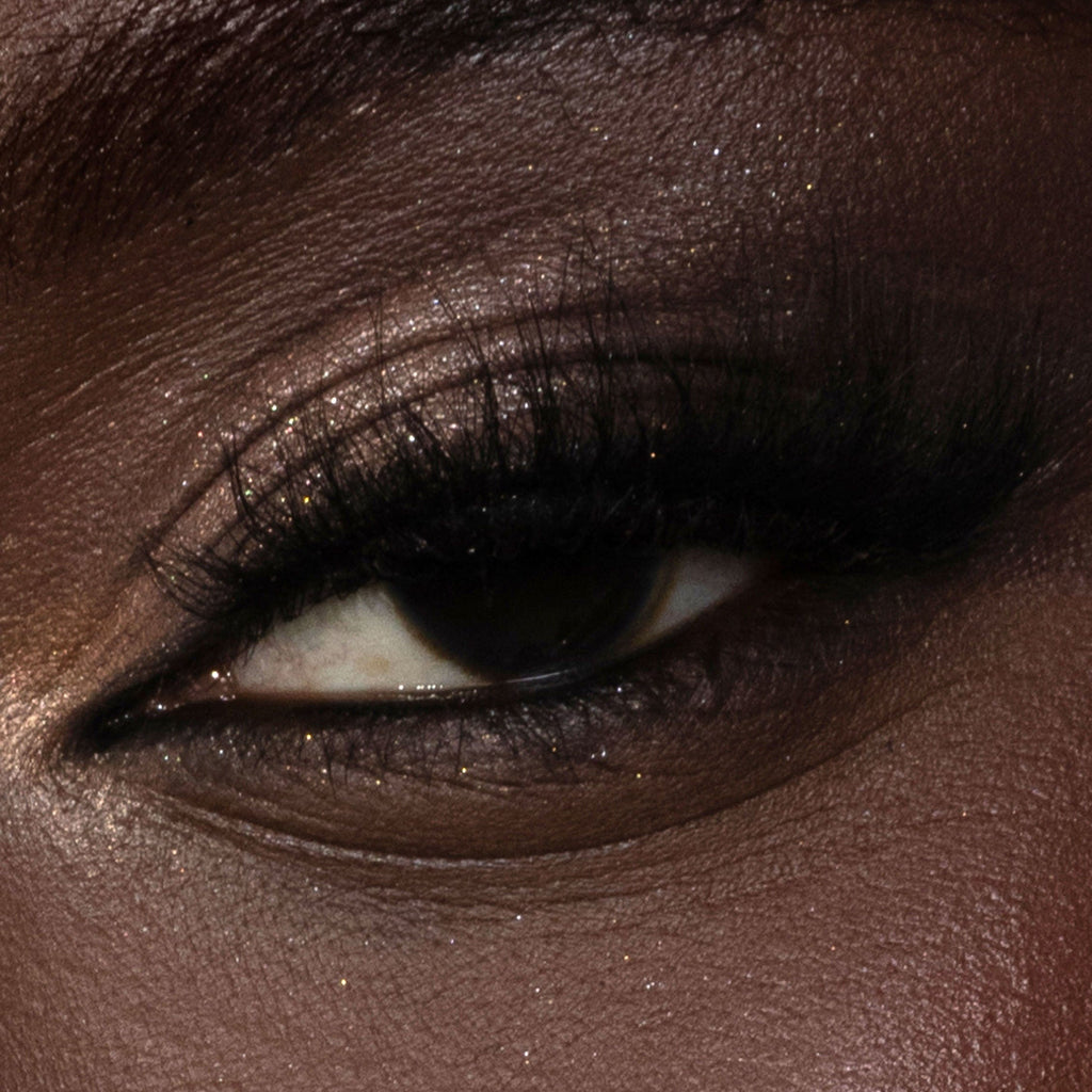 Close-up of a person's eye with dark brown eyeliner and mascara.