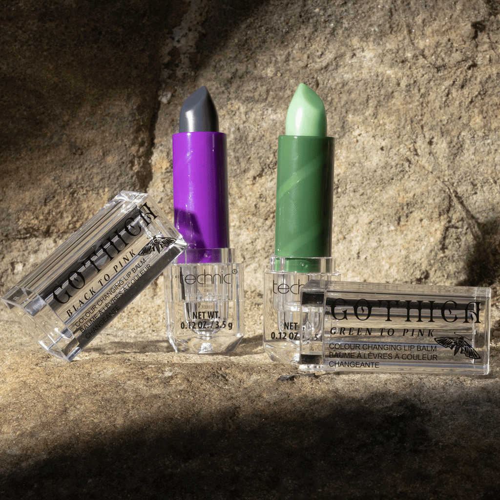 Both colours of colouring changing lip balms opened next to each other. They are stood on a stone wall with a shadow effect.