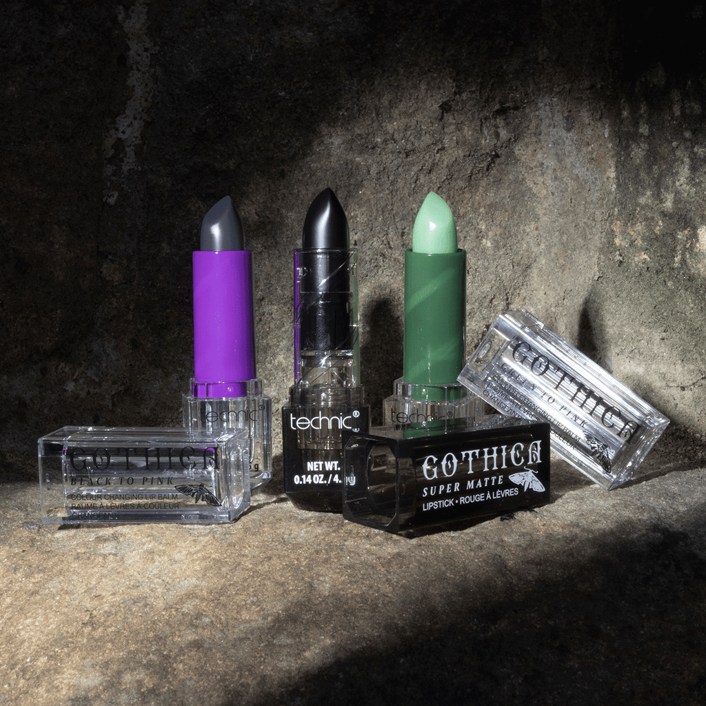 Both opened colour changing lip balms, 1 in green and 1 in purple, and an opened black lipsticks displayed on a stone wall background with a spotlight shadow onto the products.