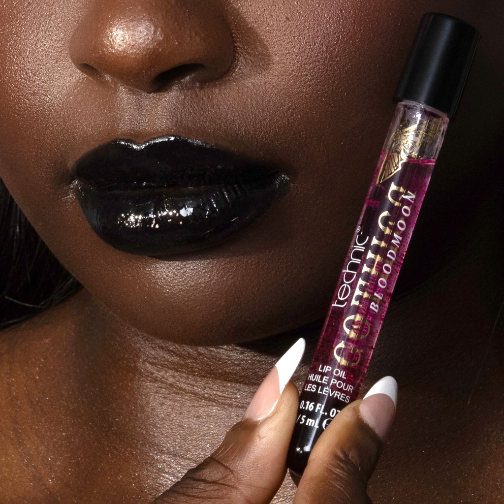 LipOIL held by a hand with dark skin against a blurred background