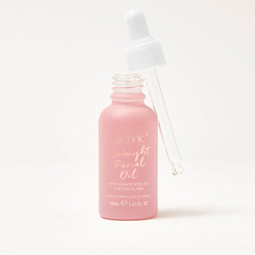 An opened overnight facial oil in front of a white background.