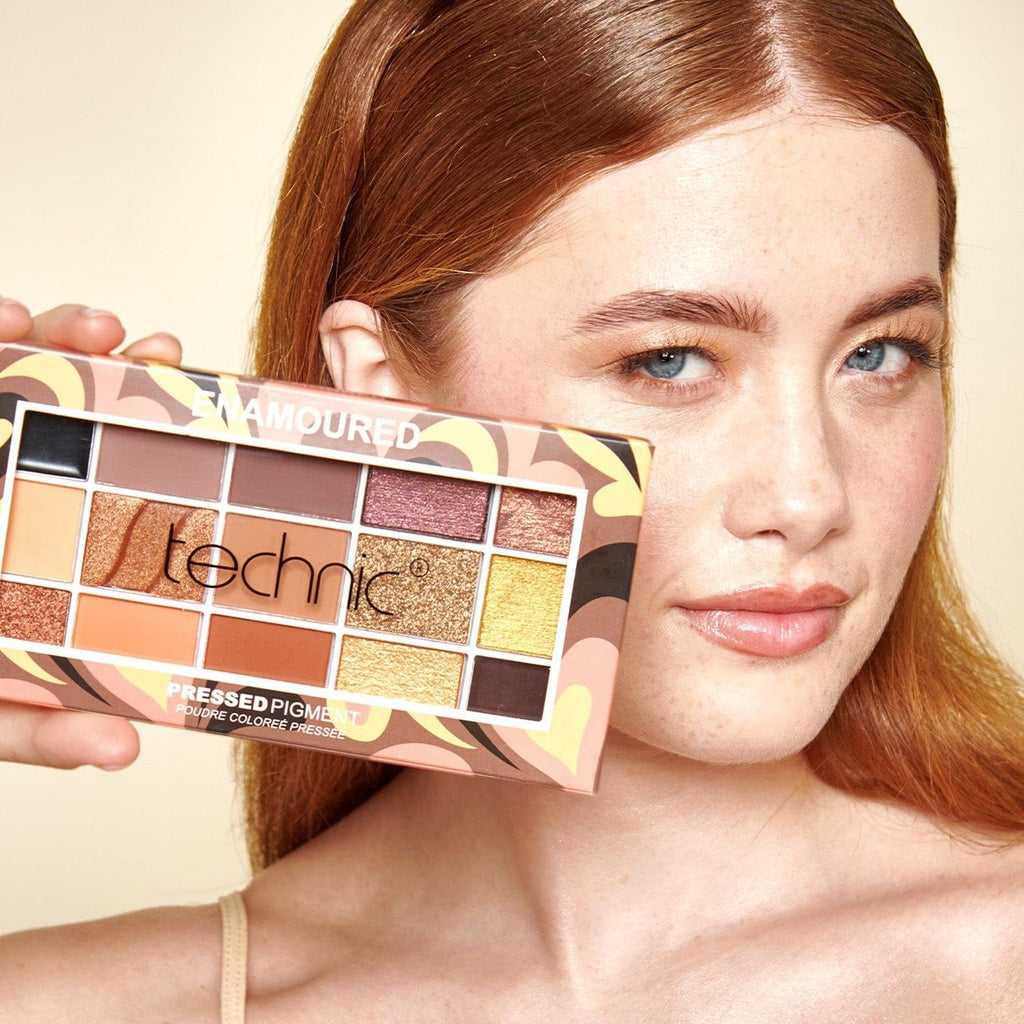 A model holding the Enamoured eyeshadow palette next to her face.