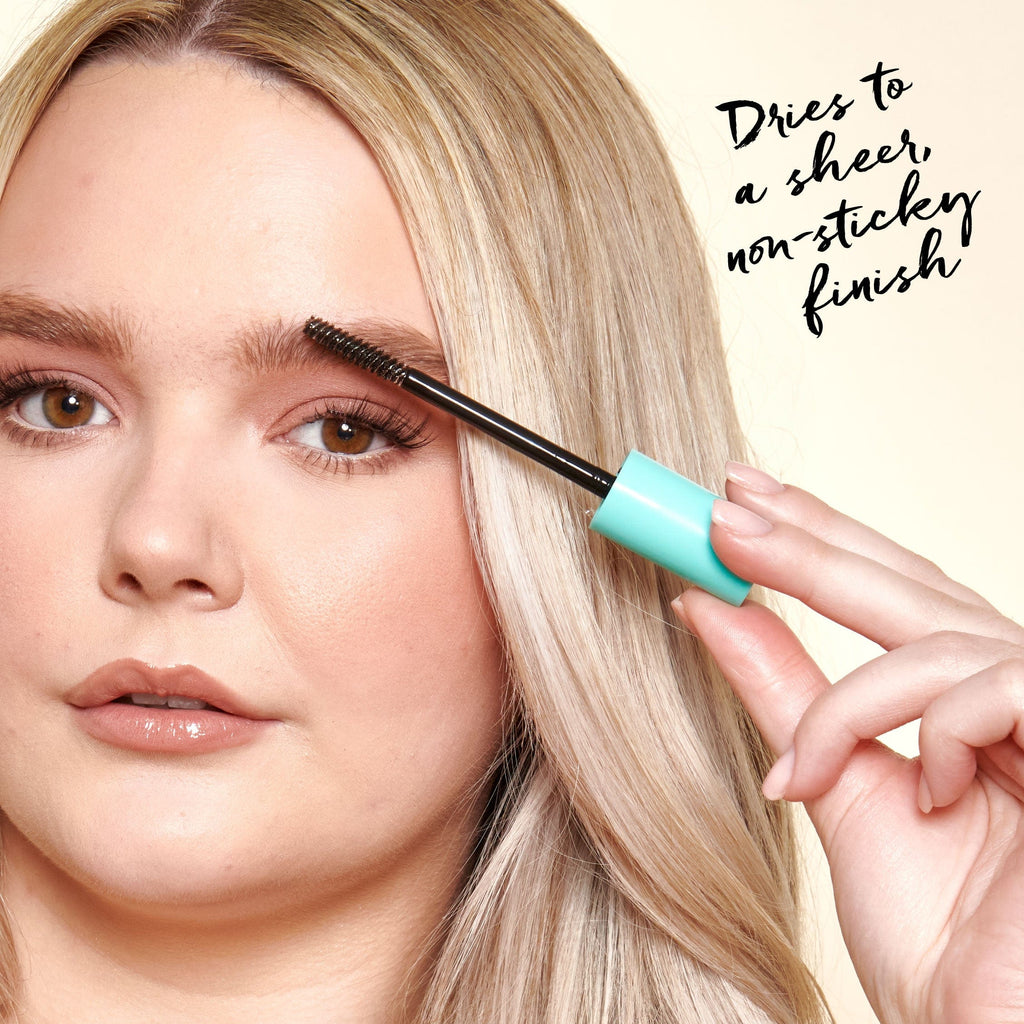 Model applying the brow gel to her eyebrows.