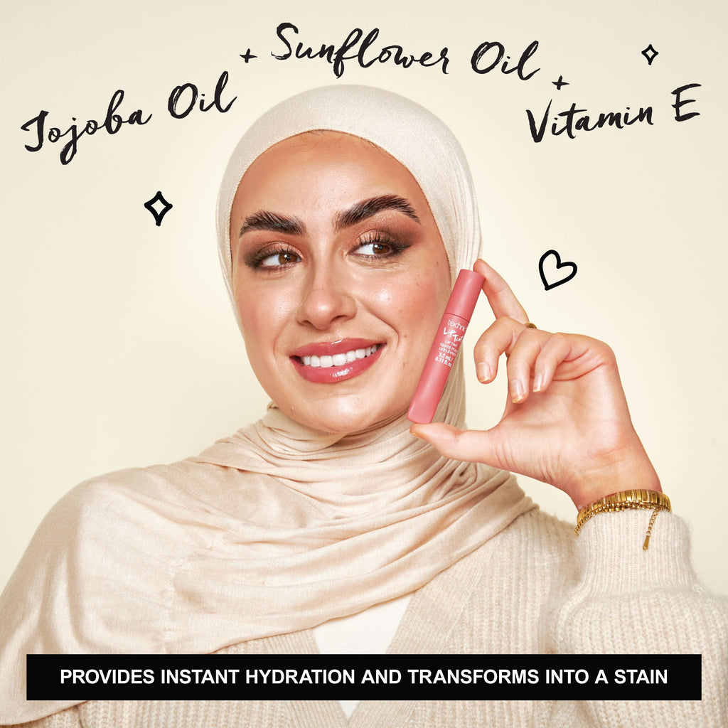 Model holding the lip tint next to her face with the key ingredients around her.