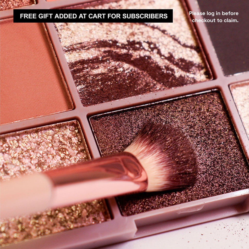 Close up of eyeshadow brush going into a shimmer shade in the palette.