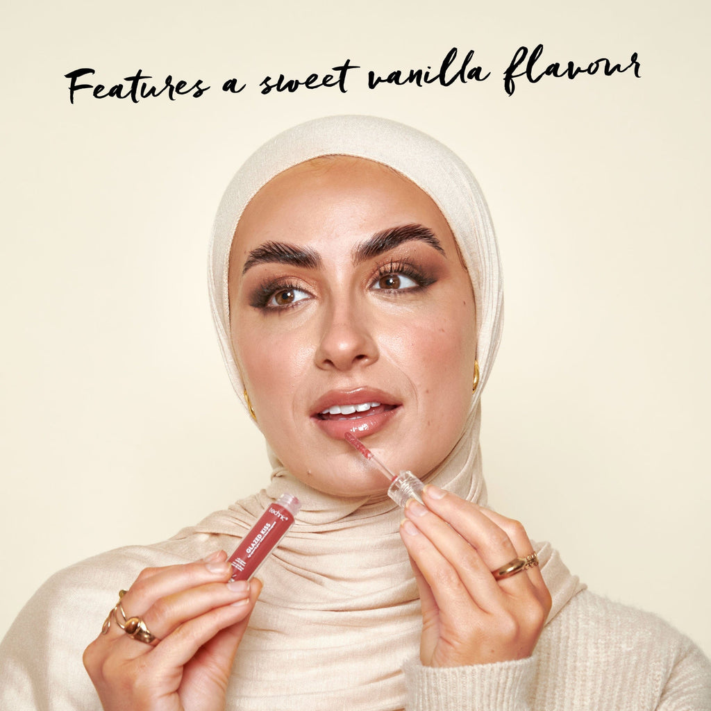 Model applying one of the shades of the glazed kiss lip glosses with text saying it features a sweet vanilla flavour.