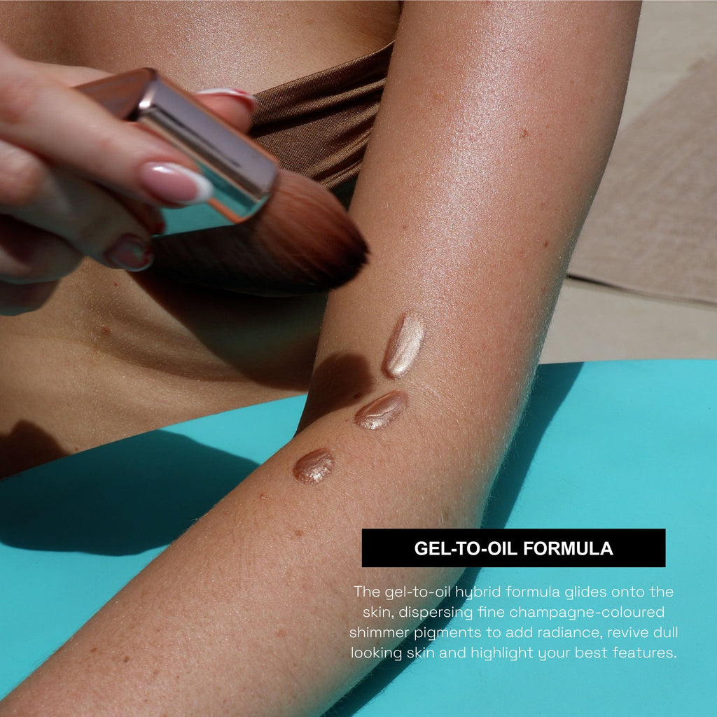 Close up of a model applying the bottled glow to her arm, holding a body brush in her hand. Text saying "Gel-To-Oil Formula"