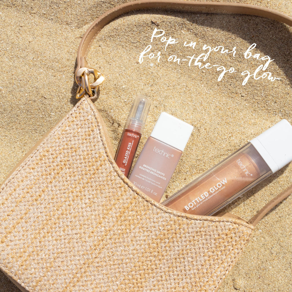 A beige woven mini handbag with a bottled glow, bronzing drops and a coloured lip gloss coming out of it. Text saying "Pop In Your Bag For On-The-Go Glow"