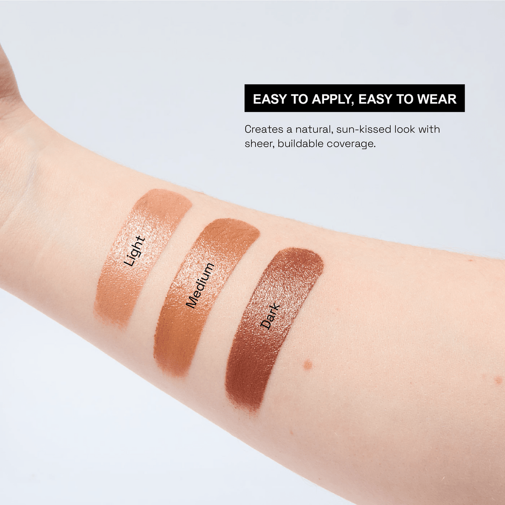 A models arm with swatches of the 3 cream bronzer shades going from lightest to darkest.  There is text that says that they are easy to apply, easy to wear and have buildable coverage that gives a sun-kissed look.
