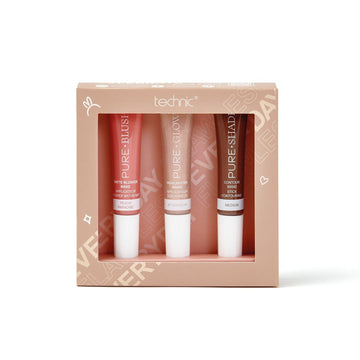 The pure glow trio gift set on a white background. The gift set is in a beige and pink box and has a blusher wand, highlighter wand and contour wand inside. The box has a cut out in the front so the products are on show.
