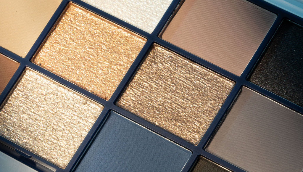 Makeup eyeshadow palette with various shades of gold, brown, and blue.