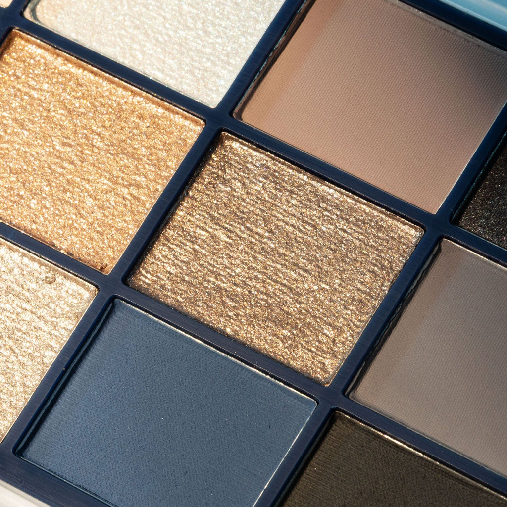 Makeup eyeshadow palette with various shades of brown, blue, and gold.