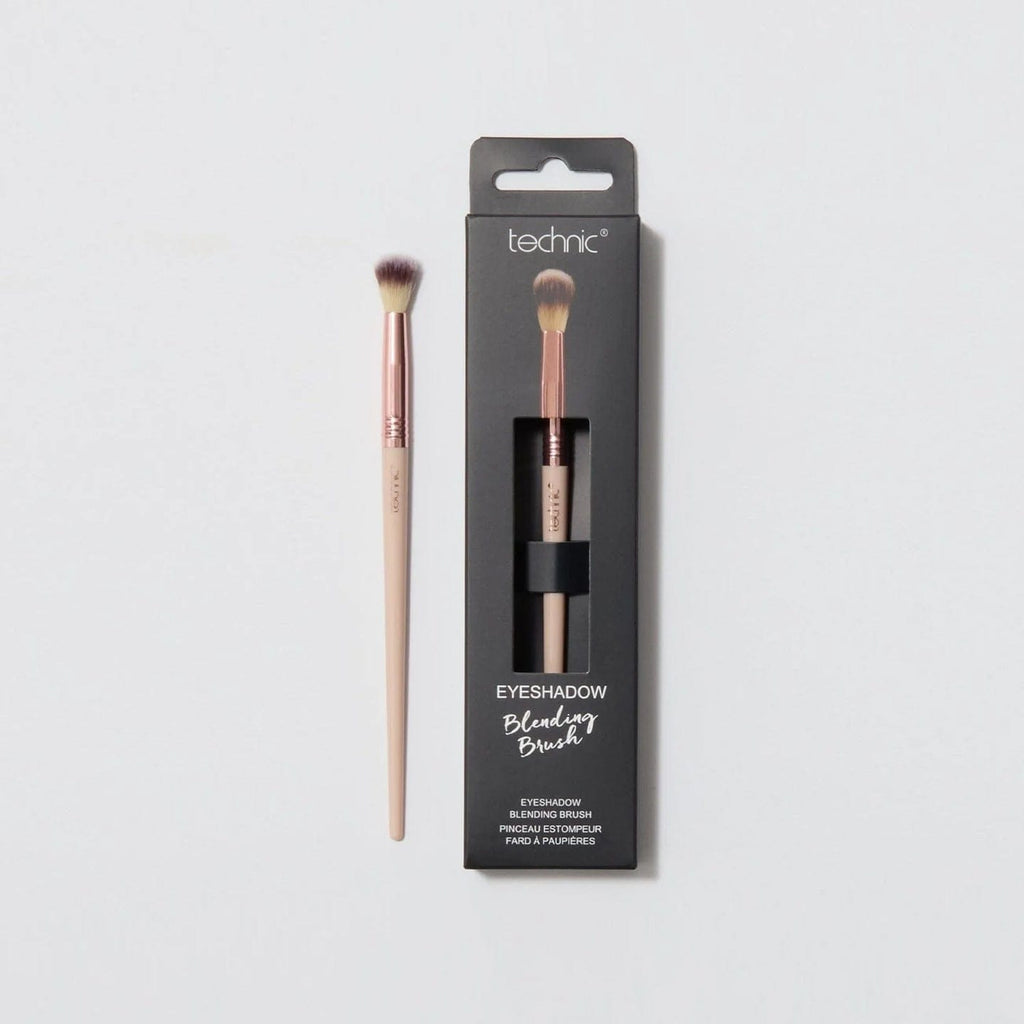 An eyeshadow blending brush in the packaging next to one out of the packaging on a white background.