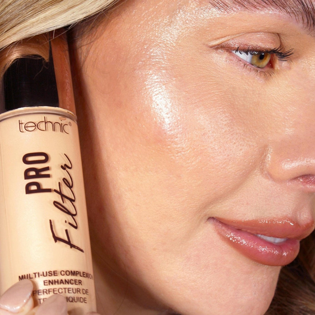 A close up of a model with the pro filter applied to her face while holding the product next to her face.
